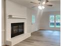 Living room with fireplace, light flooring, and backyard view at 111 Whithorne Dr, Garner, NC 27529