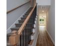 Carpeted staircase with wood handrail and black metal balusters leading to hallway at 807 E Harnett St, Dunn, NC 28334