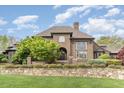 Grand brick home with manicured lawn and stone wall at 32520 Archdale Dr, Chapel Hill, NC 27517