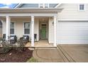 Front porch view of house entryway with green door and white siding at 82 Mariners Point Way, Garner, NC 27529