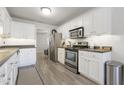 Modern kitchen featuring white cabinets, stainless steel appliances, and dark countertops at 122 Gatwick Ct, Clayton, NC 27520