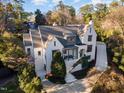 Aerial view of a charming two-story house nestled amongst lush trees at 3319 Milton Rd, Raleigh, NC 27609