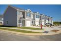 Row of townhouses with gray siding, two-car garages, and landscaping at 513 Fife Ct, Gibsonville, NC 27249