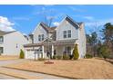 Two-story house with gray and beige siding, white garage door, and landscaping at 78 N Porcenna Ln, Clayton, NC 27527
