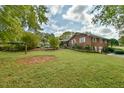Brick house with a large backyard, partially visible pool, and lush landscaping at 304 Homestead Rd. Rd, Chapel Hill, NC 27516