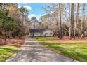 House exterior view with driveway and wooded backdrop at 4521 Old Larkin Ct, Wake Forest, NC 27587