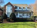 Beautiful two-story traditional home with a covered front porch, green lawn, and mature trees at 1113 Cowper Dr, Raleigh, NC 27608