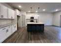 Bright, open kitchen featuring white cabinets, a contrasting island, and stainless steel appliances at 136 S Mistflower St, Clayton, NC 27520
