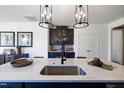 Kitchen island with a stainless steel sink, quartz countertop, and black faucet at 1788 Farm Pond Trl, Durham, NC 27703