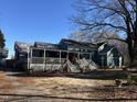 Wide view of a teal home with large front porch, lattice skirting, and trees at 403 E Railroad St, Spring Hope, NC 27882