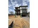 A modern three-story home viewed from an angle showing the driveway and some construction materials at 409 Waldo St, Cary, NC 27511