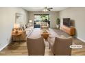 Virtually staged living room with neutral decor, wood floors, and sliding glass door to balcony at 5038 Flint Ridge Pl, Raleigh, NC 27609