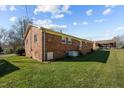 Back exterior of a brick home with a grassy backyard and a playset at 920 Essex Dr, Graham, NC 27253