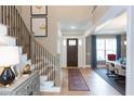 Inviting foyer with a staircase, area rug, and views of the adjacent dining area at 9520 Wood River Dr, Zebulon, NC 27597