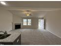 Open living room with vaulted ceiling, fireplace, carpet flooring, and natural light at 193 Magnolia Run Way, Benson, NC 27504