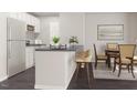 Modern kitchen with white cabinets, dark countertops, stainless steel appliances, and an island with seating at 228 Maggie Ln, Roxboro, NC 27573