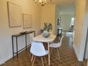 Bright dining area with parquet floors, white dining table and chairs, and hallway access at 3738 Jamestown Cir, Raleigh, NC 27609