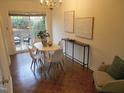 Dining room with parquet flooring, white oval table with four chairs, and sliding glass doors at 3738 Jamestown Cir, Raleigh, NC 27609