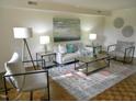 Living room with hardwood floors, stylish furniture, soft color sofa and armchair, and modern decor at 3738 Jamestown Cir, Raleigh, NC 27609