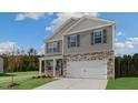New two-story home with stone accents, front porch, and attached two-car garage at 432 Ashley Run, Sanford, NC 27330