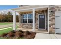 Covered front porch with stone accents and dark gray front door at 432 Ashley Run, Sanford, NC 27330