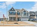 Inviting two-story home with a covered front porch, landscaped yard, and attached garage at 1012 Whispering Creek Ct, Knightdale, NC 27545