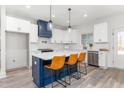 Modern kitchen with white cabinets, blue island, and stainless steel appliances at 4037 Mebane Oaks Rd, Mebane, NC 27302