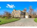 Three-car garage and paved driveway of a large brick home on a landscaped lot at 4109 Cheek Point Pl, Burlington, NC 27215