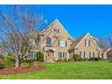 Brick home with stone accents, mature trees, and a well-maintained lawn at 4109 Cheek Point Pl, Burlington, NC 27215