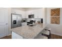 Bright and spacious kitchen featuring white shaker cabinets, stainless appliances, and a large island at 466 Belgian Red Way, Wake Forest, NC 27587