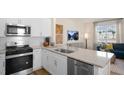 Modern kitchen with white cabinets, stainless steel appliances, granite countertops, and an island with seating at 466 Belgian Red Way, Wake Forest, NC 27587