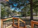 Wooden front porch steps with black railings overlooking a tree-lined street at 107 Forest Landing Dr, Garner, NC 27529