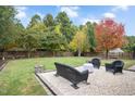 Landscaped backyard with patio furniture and fire pit at 1308 Fenwick Pkwy, Durham, NC 27713