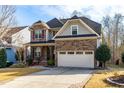 Inviting two-story home featuring a stone and siding facade, a front porch, and an attached garage at 2057 Tordelo Pl Pl, Apex, NC 27502