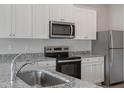 Modern kitchen featuring white shaker cabinets, stainless steel appliances, and granite countertops at 604 Rhino Bnd, Oxford, NC 27565