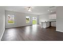 Spacious living area with wood-look flooring, ceiling fan, and sliding glass doors leading to the backyard at 604 Rhino Bnd, Oxford, NC 27565