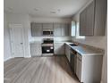 Modern kitchen featuring gray cabinets, granite countertops, and stainless steel appliances at 82 Vili Dr, Broadway, NC 27505