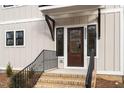 Modern front entrance with a dark brown door and black metal railing at 2222 Woodrow St, Durham, NC 27705