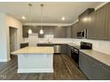 Modern kitchen with gray cabinets, granite countertops, and stainless steel appliances at 523 Eversden Dr, Zebulon, NC 27597