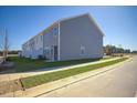 Rear view of townhome showcasing gray siding and a private patio at 301 Cherry Laurel Dr, Sanford, NC 27332