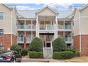 Three-story building with light beige siding, balconies, and a staircase at 524 Glenolden Ct, Cary, NC 27513