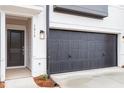 Attached garage with a black sectional door and exterior lighting at 1042 Westerland Way # 213, Durham, NC 27703