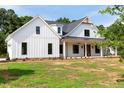 White farmhouse exterior with a spacious front yard and large covered porch at 2308 Hardwood Dr, Hillsborough, NC 27278