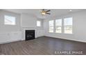 Spacious living room featuring hardwood floors, fireplace, and built-in shelving at 409 Reinsman Ct, Mebane, NC 27302