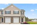 Tan two-story townhome with a two-car garage and landscaping at 5512 Henley Ridge Dr # 191, Graham, NC 27253