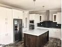Modern kitchen featuring white cabinets, a large island, and stainless steel appliances at 6016 Charlies Deadend Rd, Efland, NC 27243