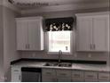 White shaker cabinets, marble countertops, and a double sink at 6016 Charlies Deadend Rd, Efland, NC 27243