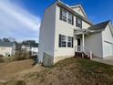 Two-story house with a white vinyl exterior, and a partial view of the backyard at 7041 Spanglers Spring Way, Raleigh, NC 27610