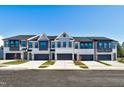 Row of townhouses with gray and white exterior, 2-car garages, and landscaping at 1012 Westerland Way # 201, Durham, NC 27703