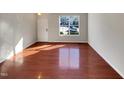 Hardwood floor living room with large window and natural light at 1302 Denmark Manor Dr, Morrisville, NC 27560